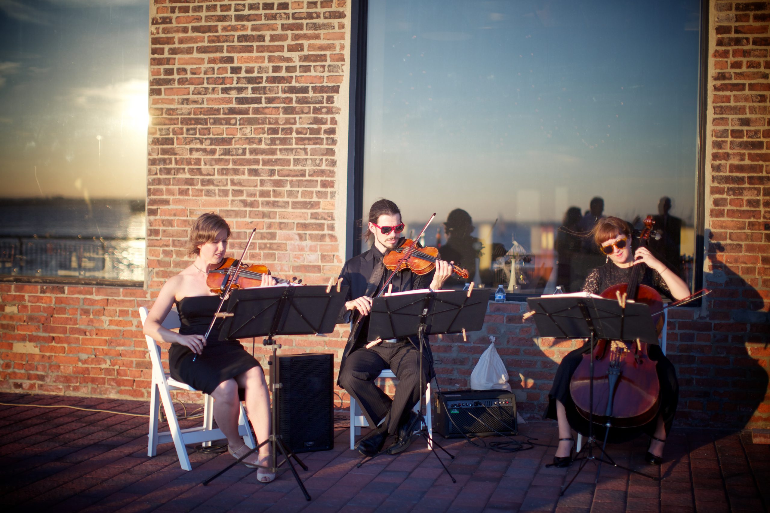 String trio plays pop music at wedding cocktail hour
